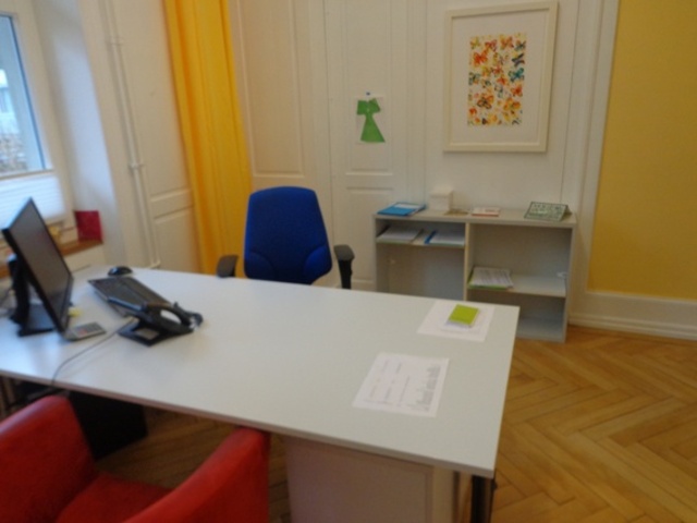 Bürotisch mit zwei Stühlen, Computerbildschirm und Schreibtisch